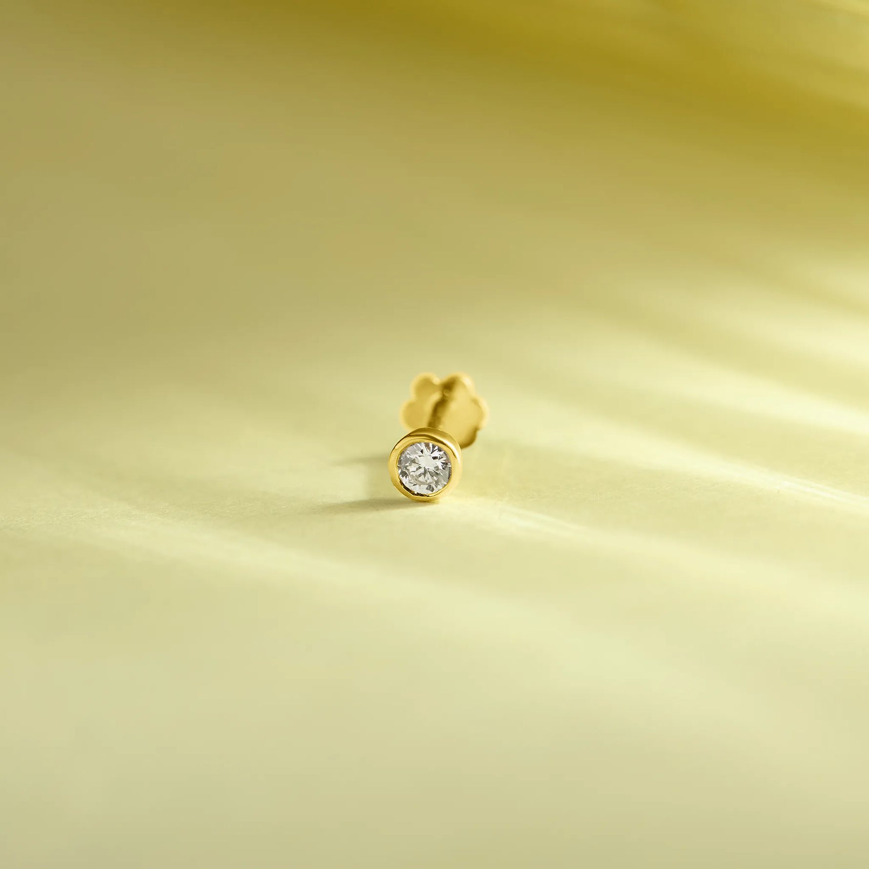 Simple gold nose pin design product image on soft pastel background