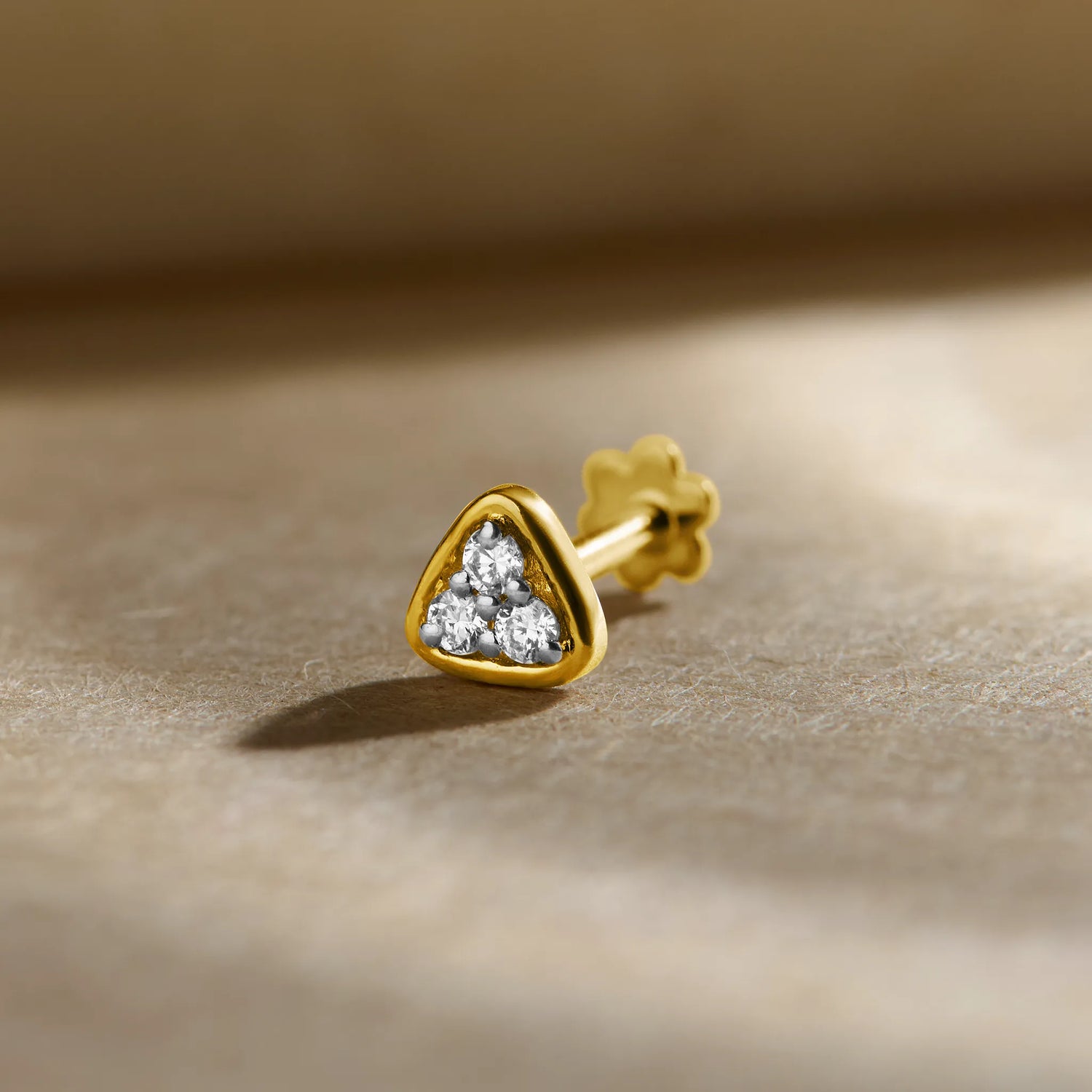 Gold Nose Pin close-up with heart-shaped stone set in polished gold on a soft background