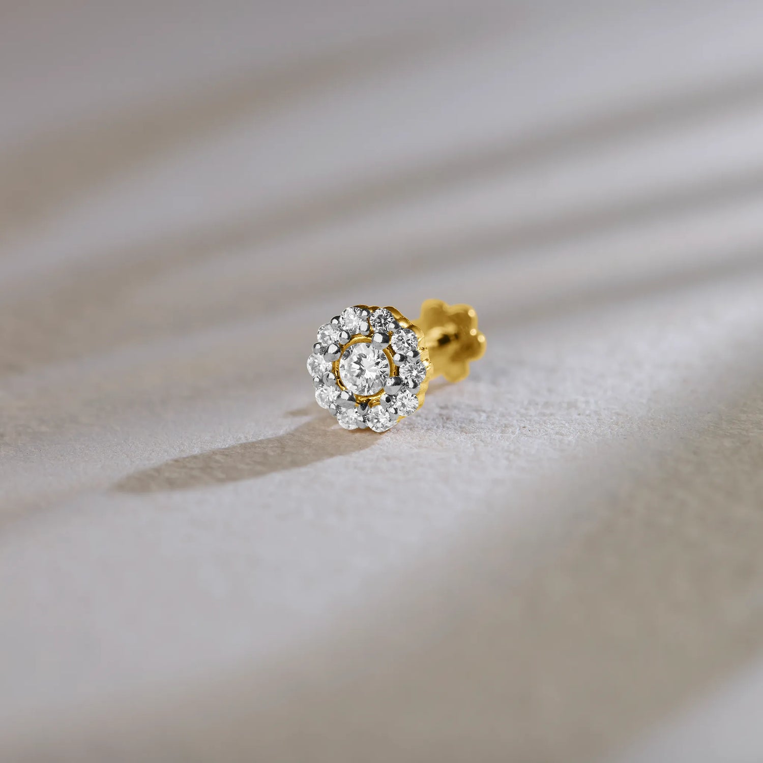 Round halo lab grown gold nose pin with center diamond on soft background