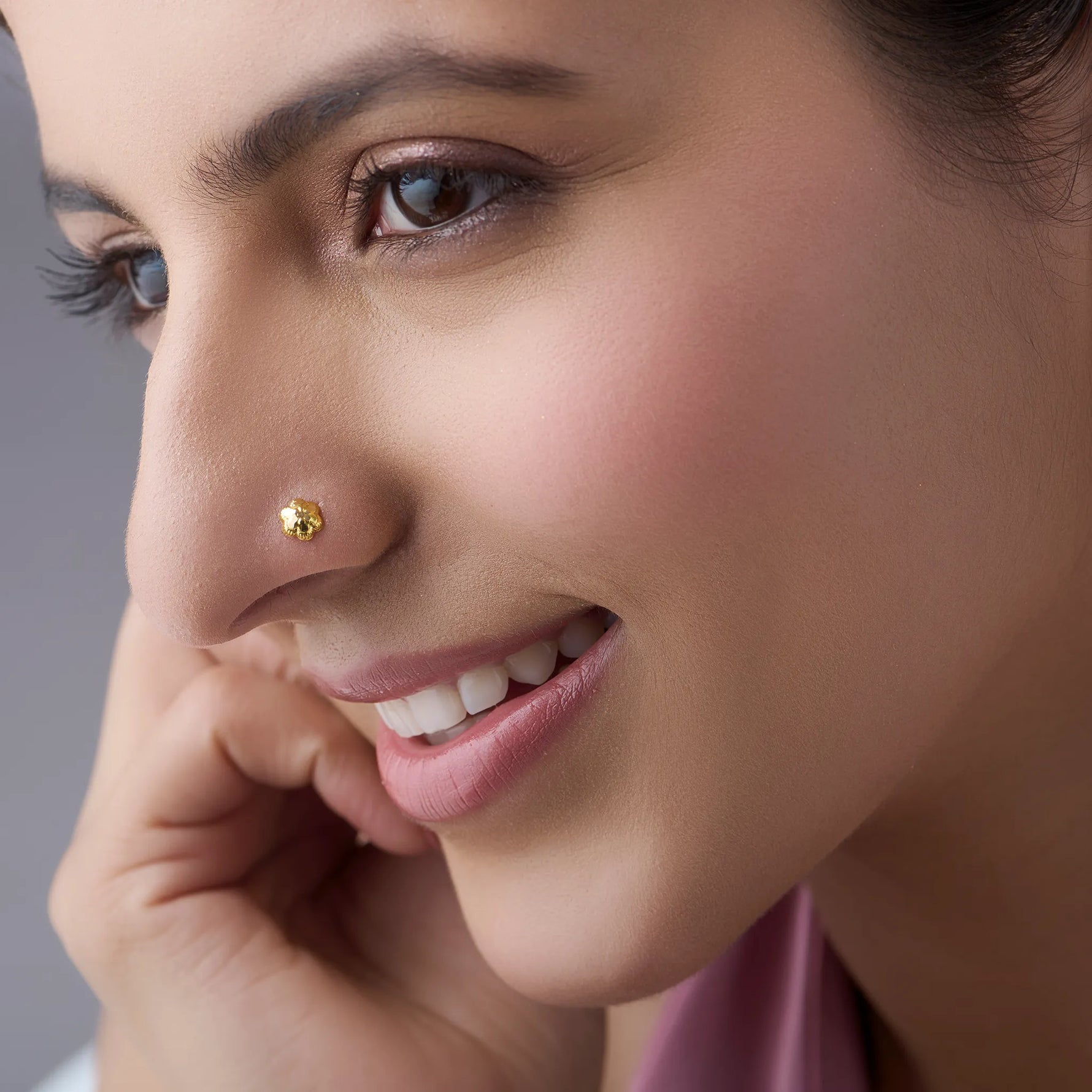 Woman wearing a small 18K gold nose pin showcasing a soft elegant everyday look