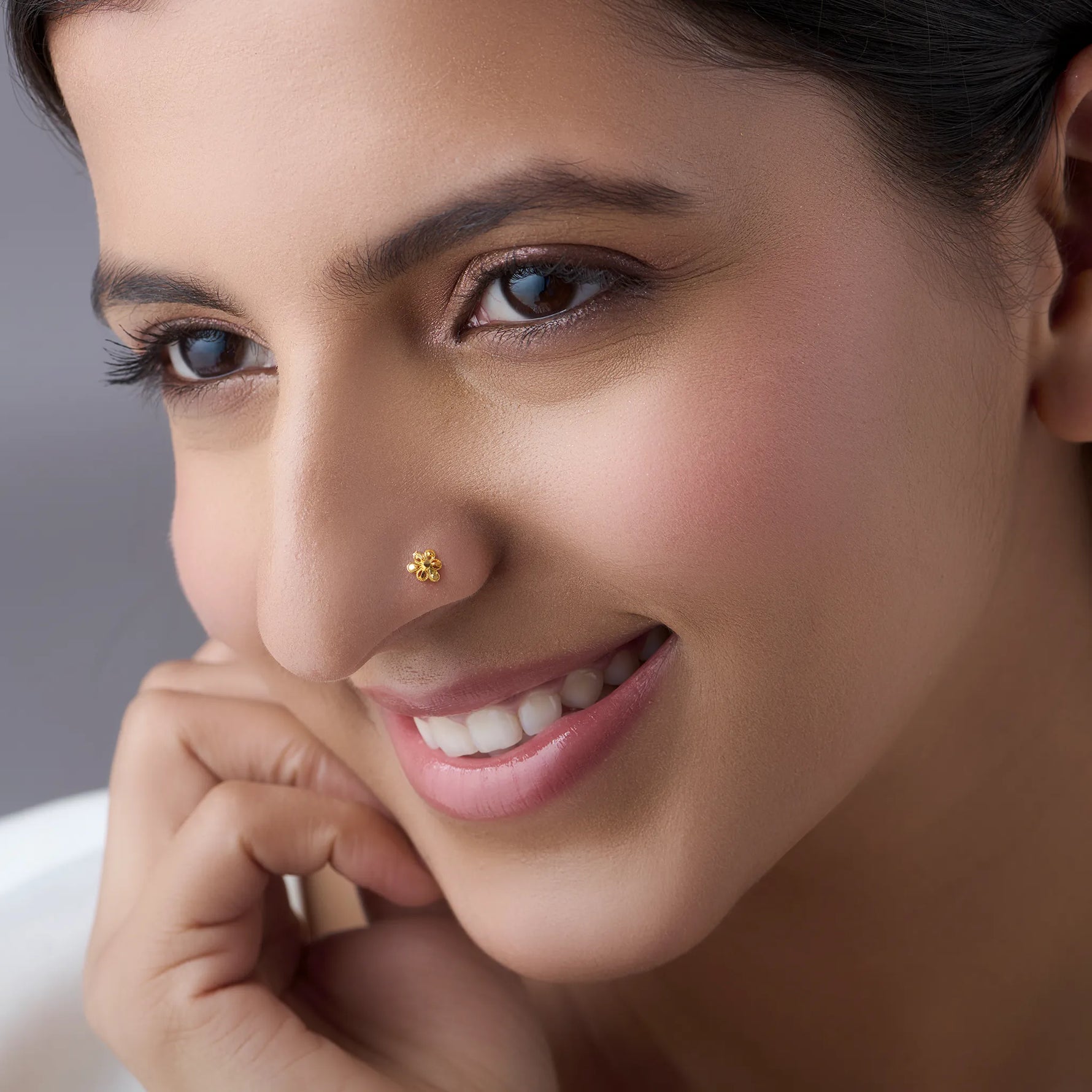Woman wearing a floral 18K nose pin gold showcasing a graceful everyday look with a soft elegant expression