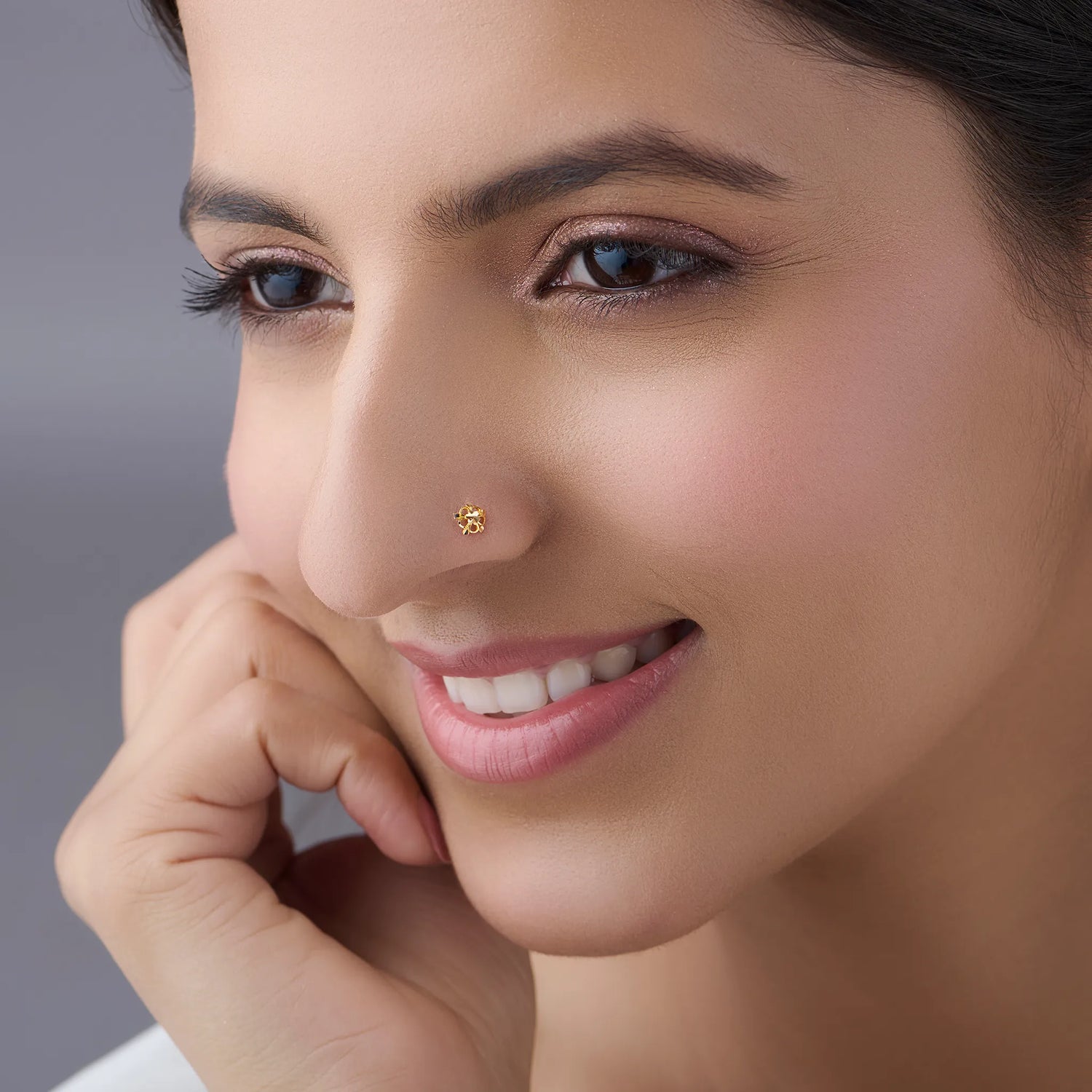 Woman wearing a delicate 18K gold floral nose pin highlighting its elegant everyday appeal