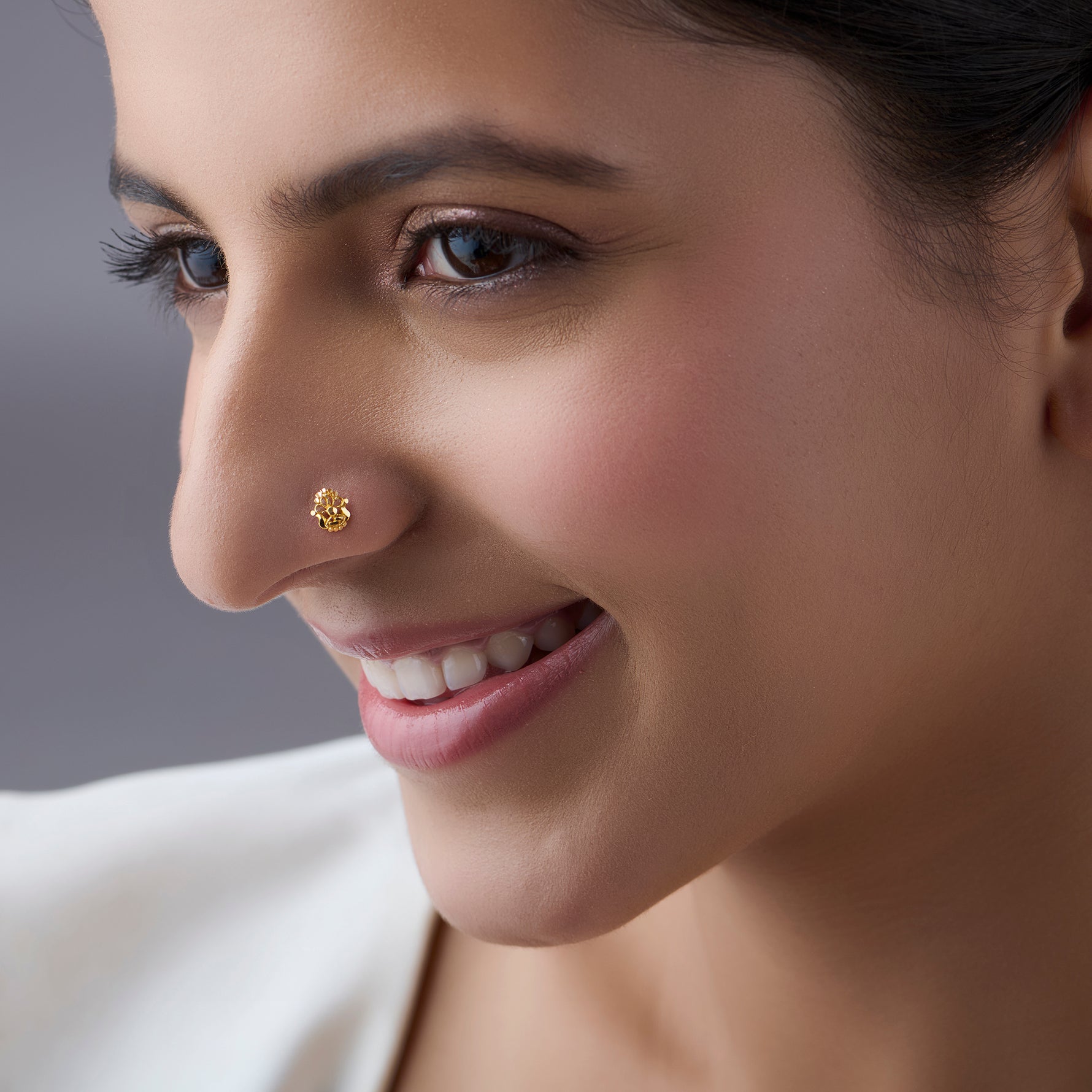 Woman wearing a small gold nose pin showcasing a soft smile and elegant everyday look