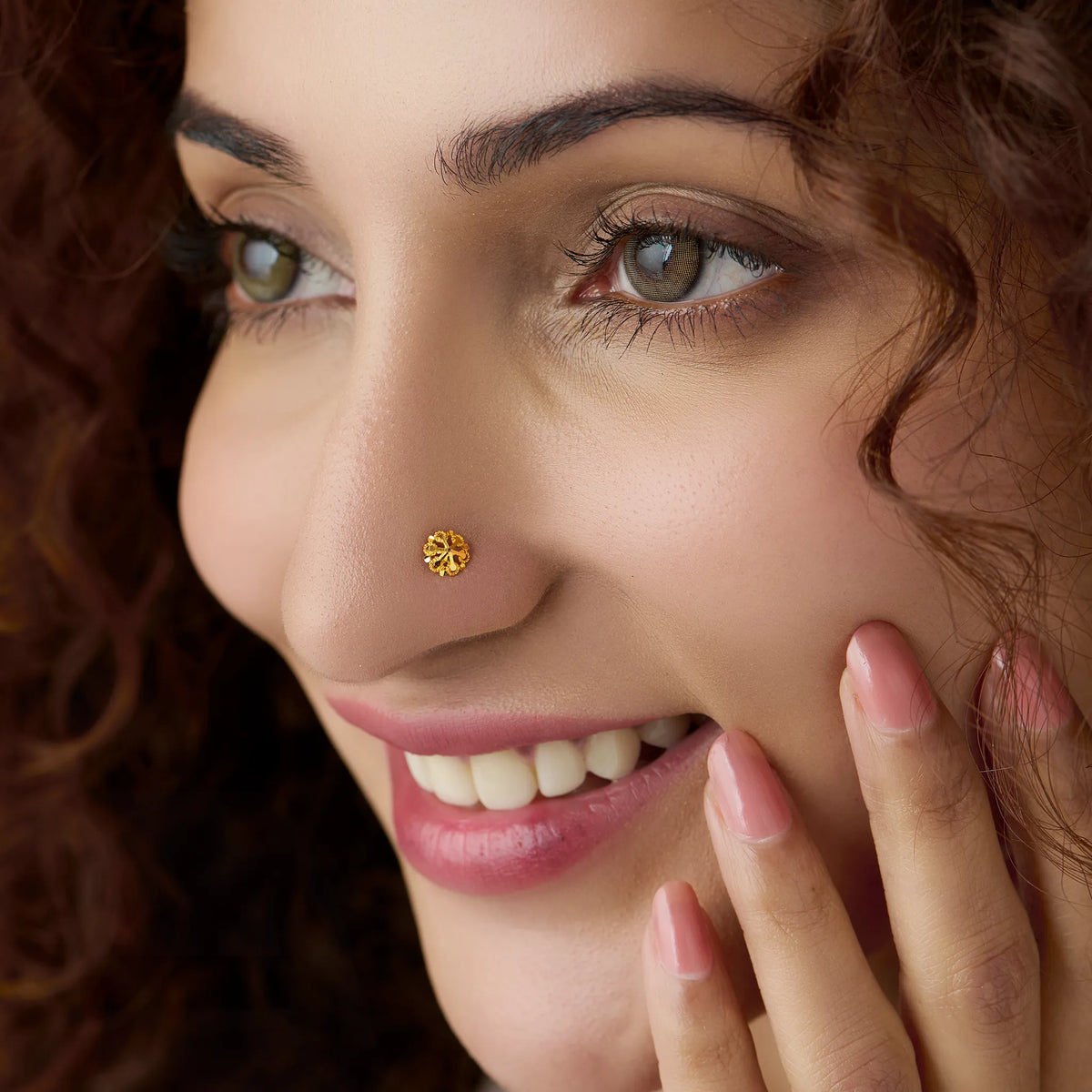 Woman wearing a delicate floral gold nose pin showing a soft everyday styling look