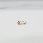 Alternate angle view of small open hoop gold nose ring on a white background showing clasp opening